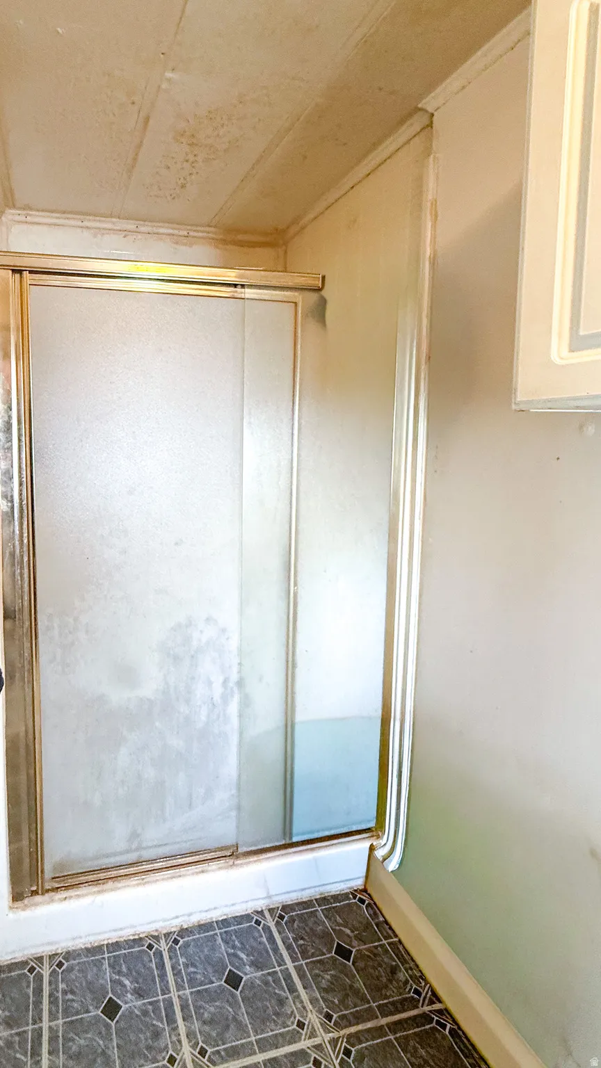 Bathroom featuring a stall shower and dark tile patterned floors