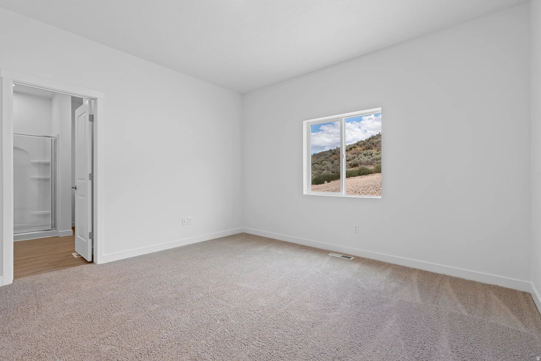 Unfurnished room featuring light colored carpet and baseboards