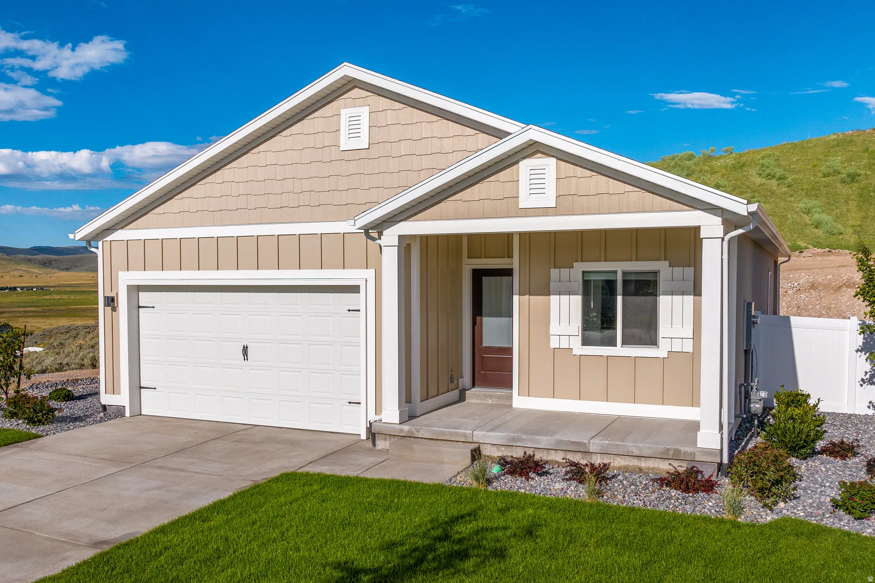 View of front of house featuring covered porch, driveway, an attached garage, board and batten siding, and a mountain view