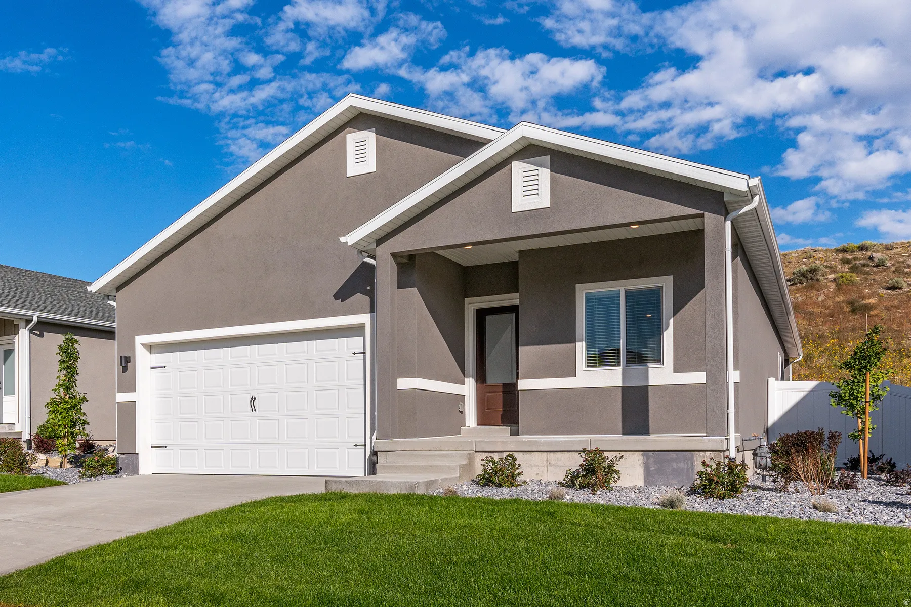 View of front of home featuring stucco siding, driveway, a garage, and a porch