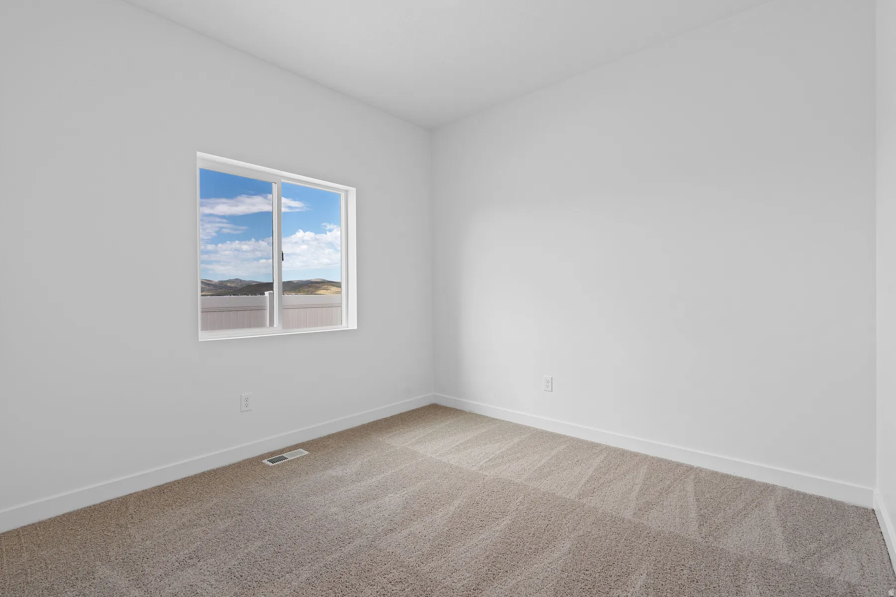 Carpeted empty room featuring baseboards