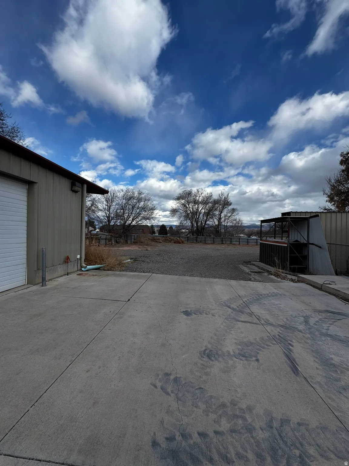 View of yard featuring an outbuilding and concrete driveway