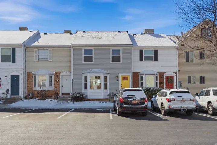 Colonial inspired home featuring a chimney, entry steps, uncovered parking, and brick siding