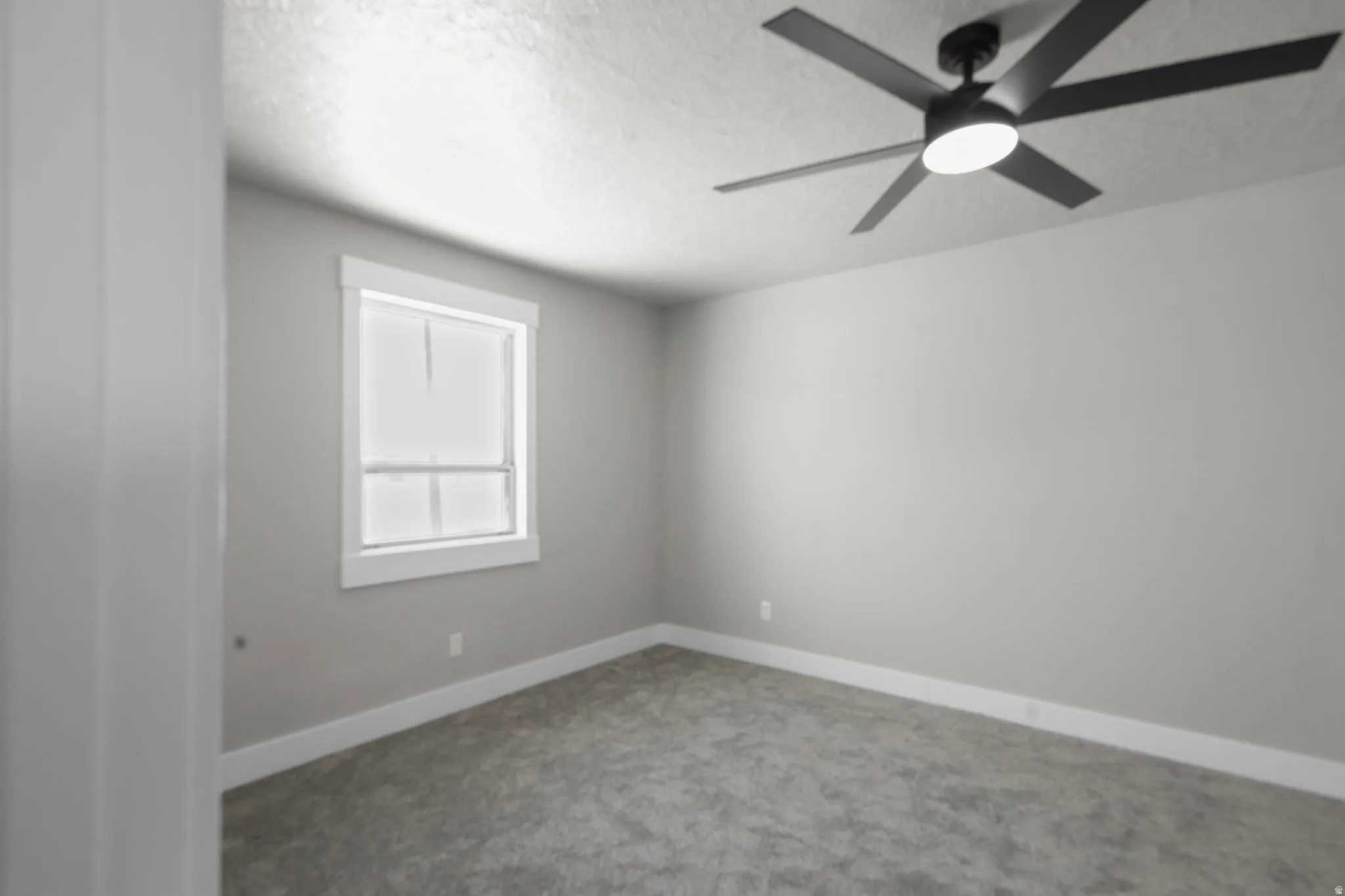 Empty room with carpet flooring, a textured ceiling, and ceiling fan