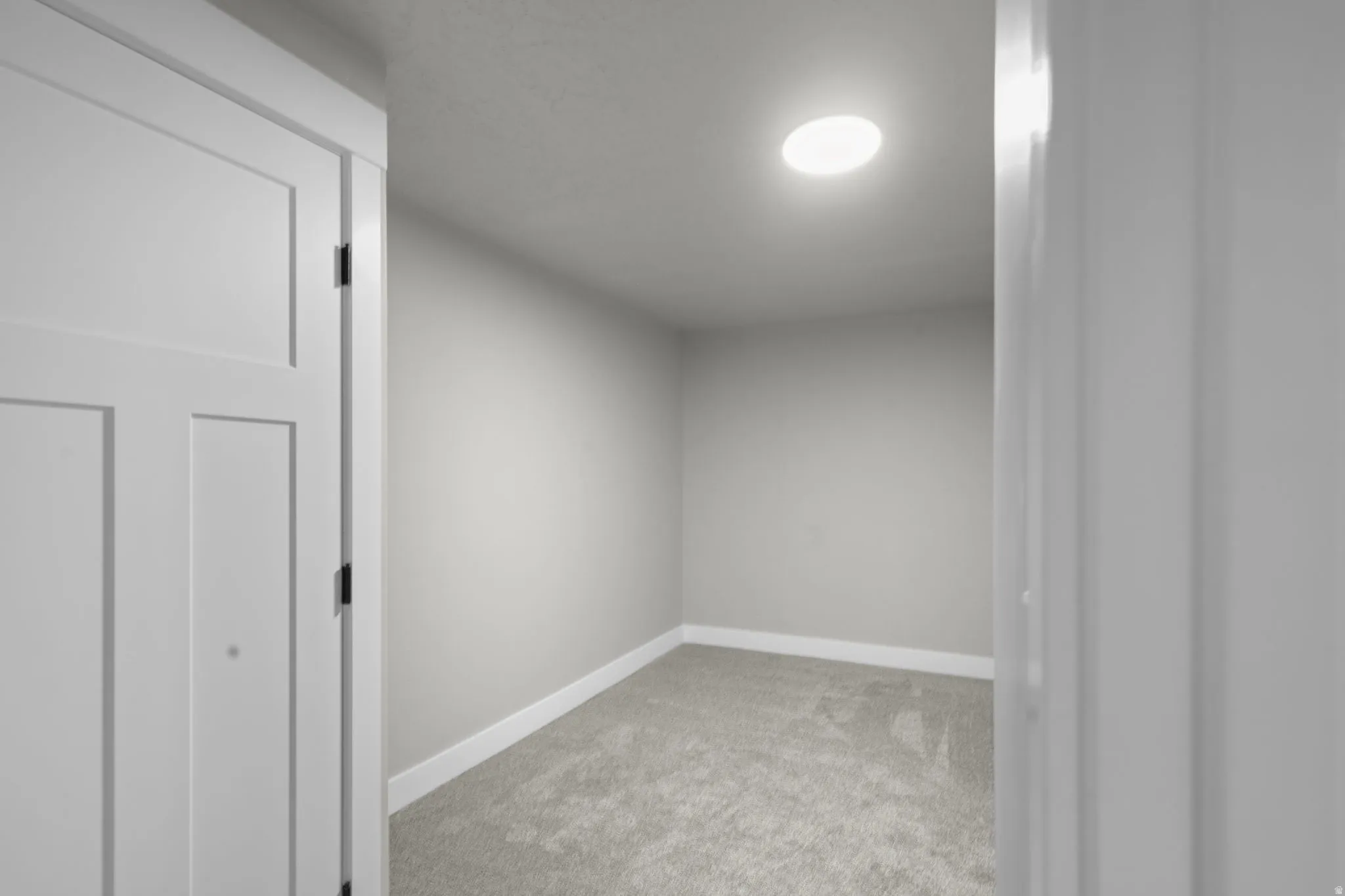 Unfurnished room featuring light carpet and baseboards