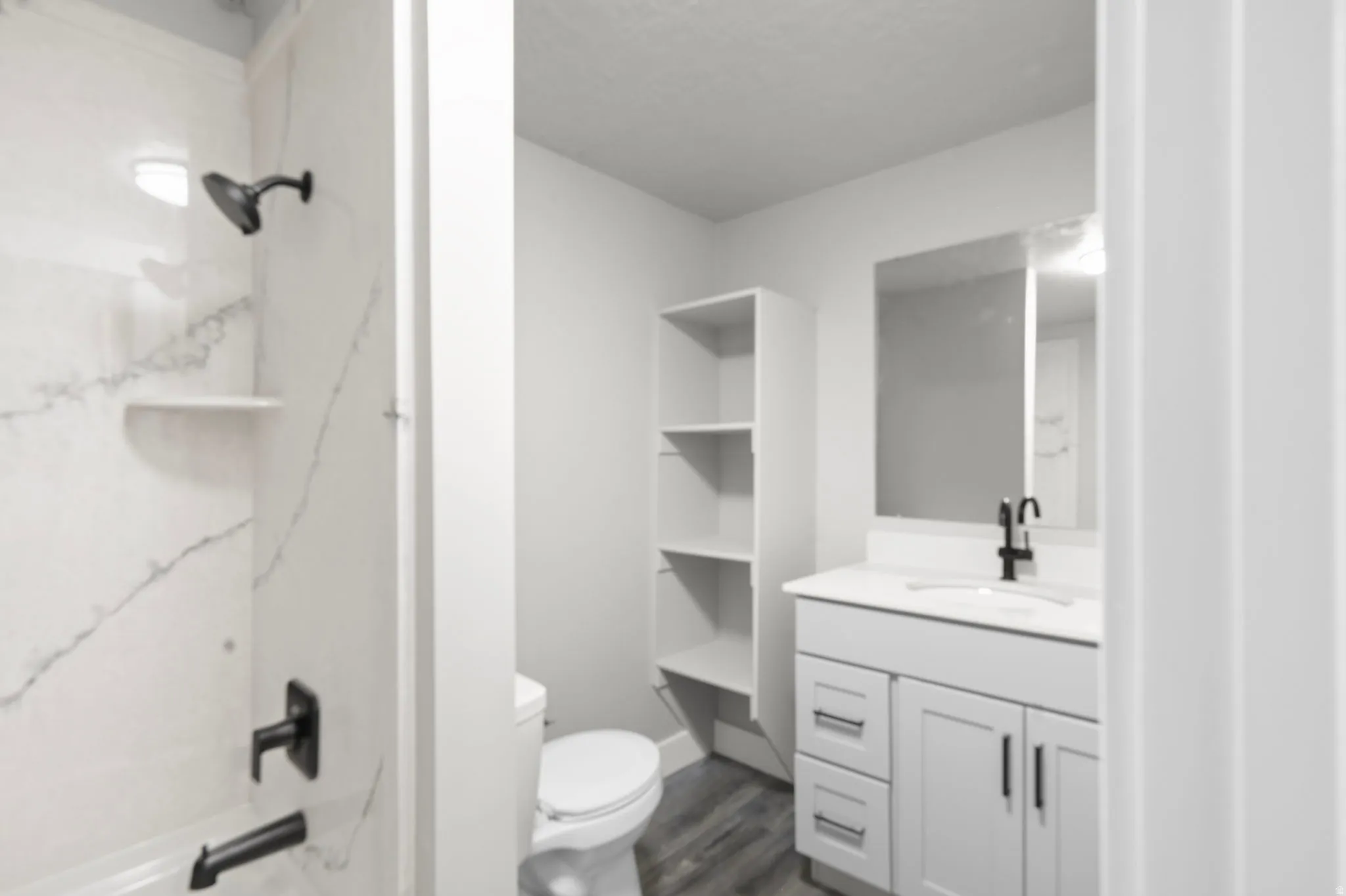 Full bathroom featuring vanity, a combined bath / shower with marble appearance, and dark wood-style floors