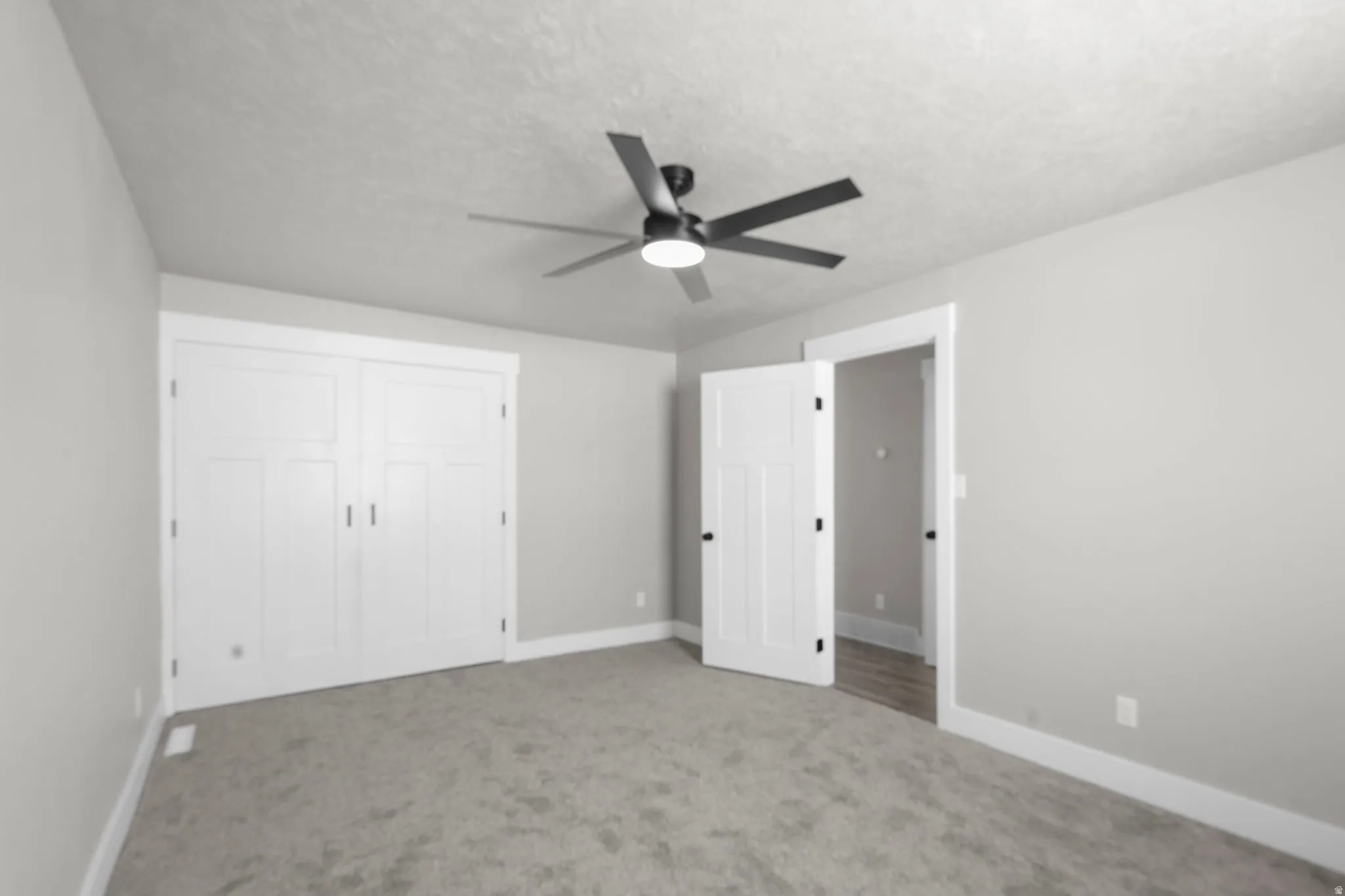 Unfurnished bedroom with carpet floors, ceiling fan, a textured ceiling, and a closet