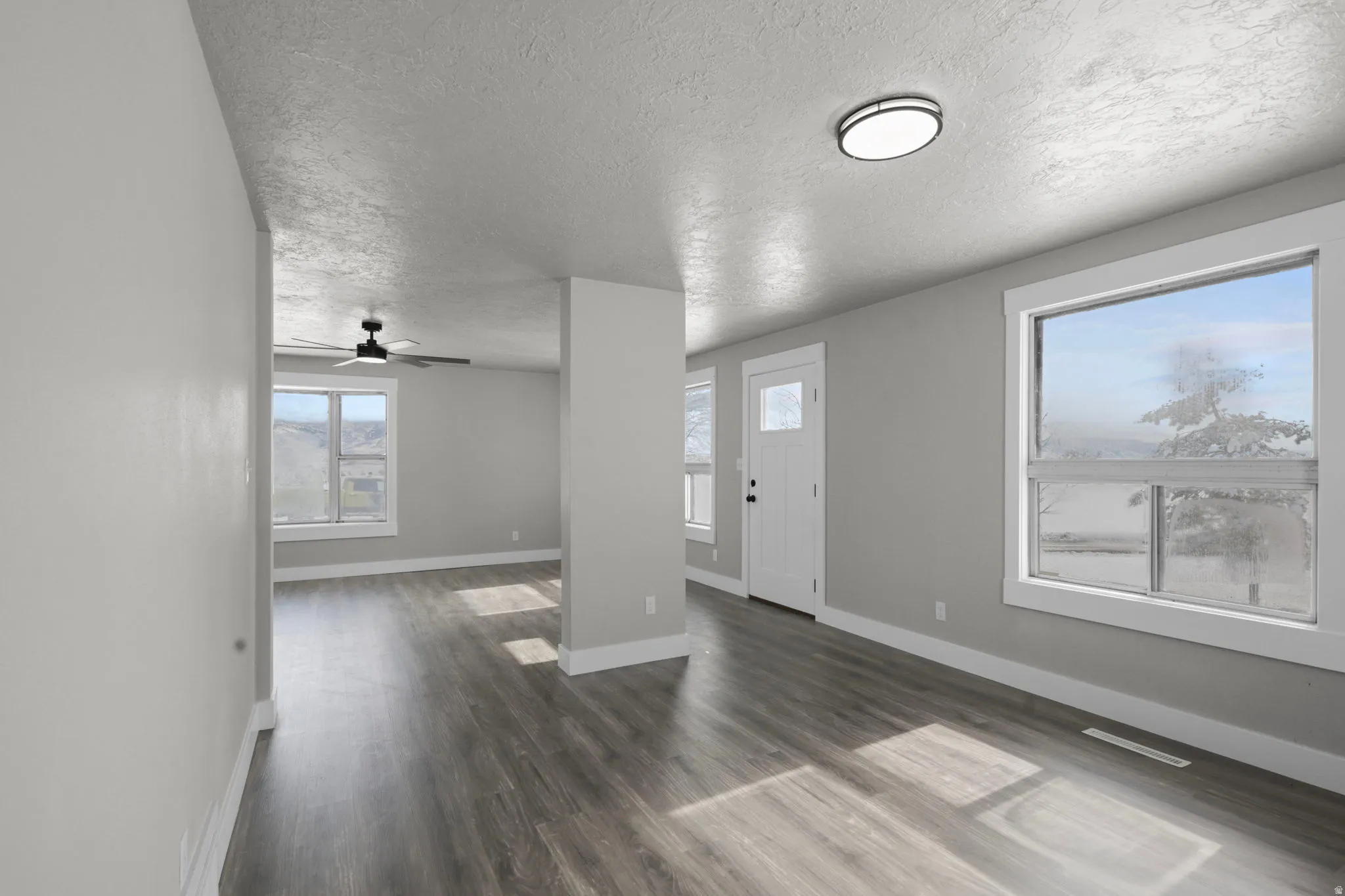 Foyer featuring dark wood-style flooring, a textured ceiling, and ceiling fan