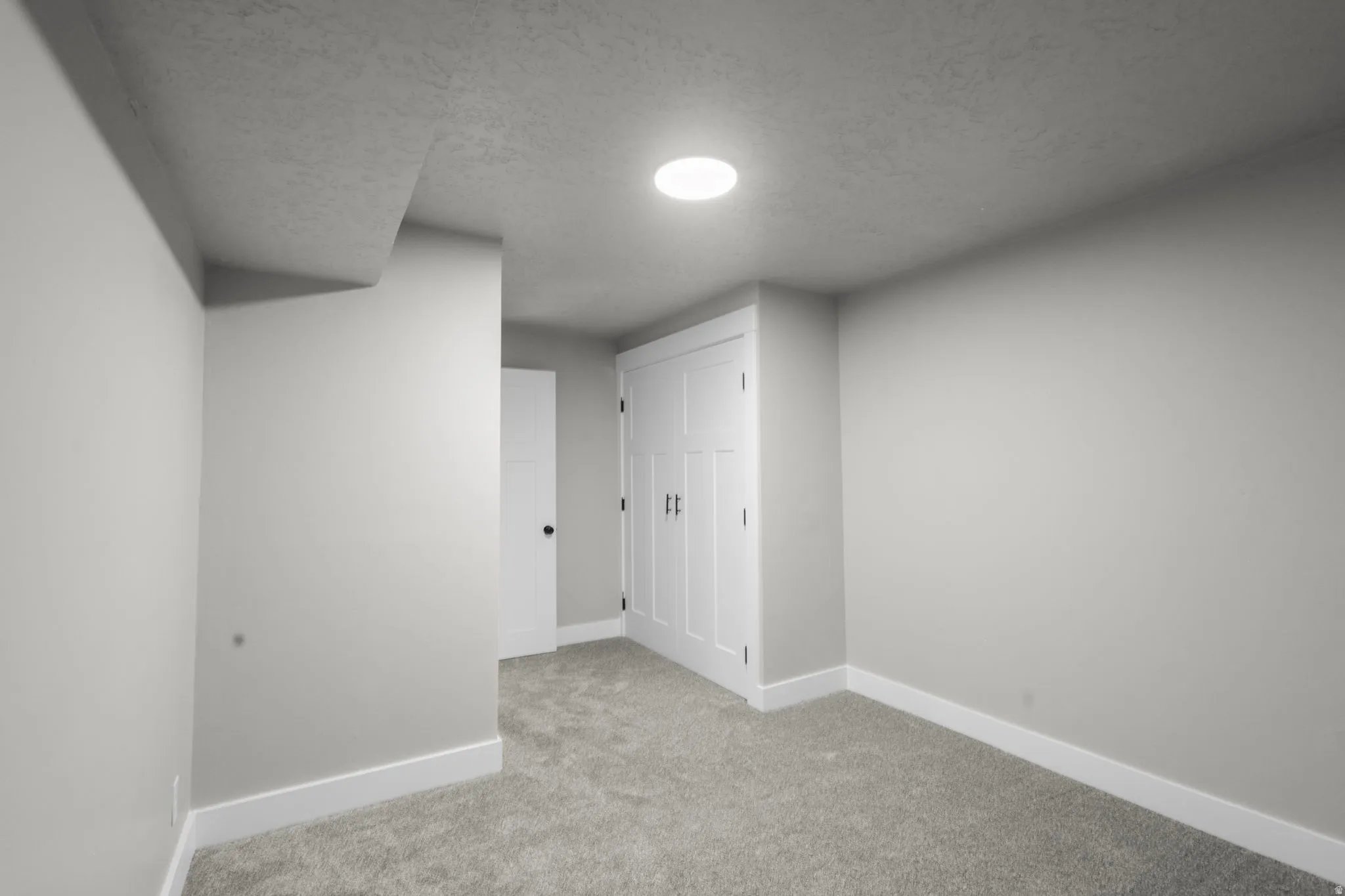 Bonus room with carpet and a textured ceiling