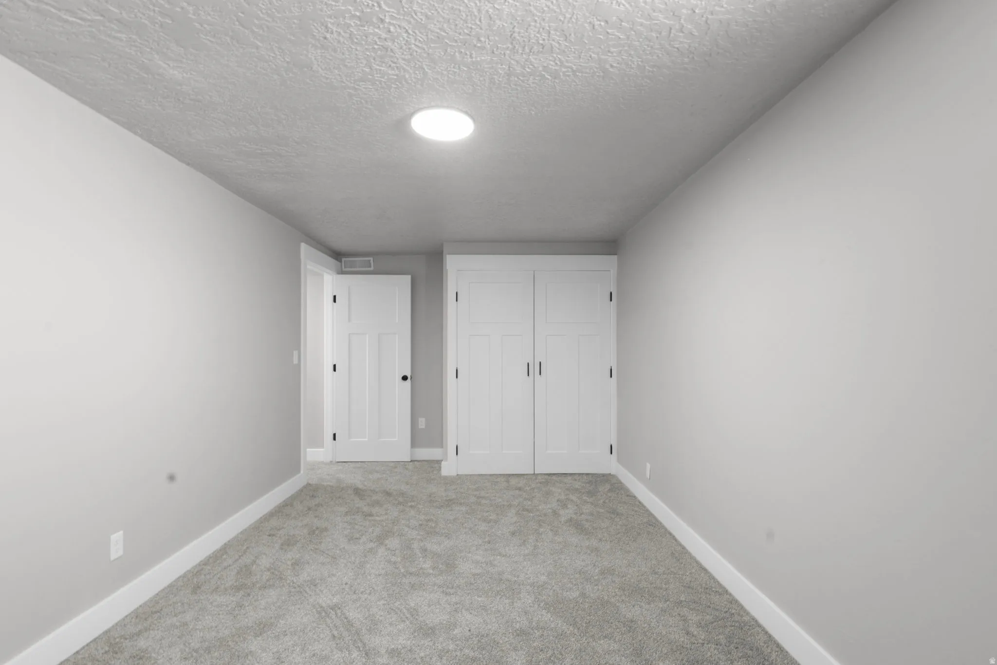 Unfurnished bedroom with carpet flooring, a closet, and a textured ceiling