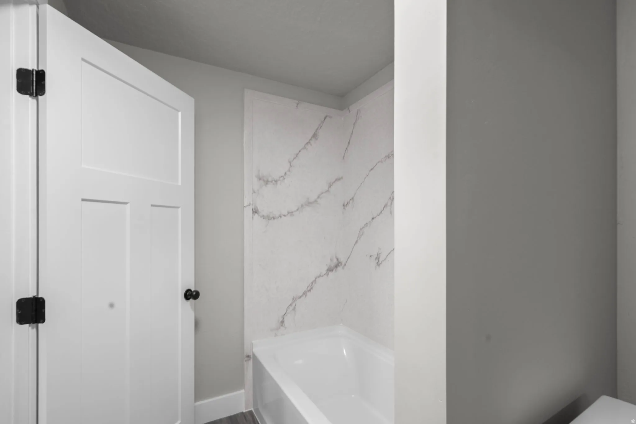 Full bath featuring a tub to relax in and baseboards
