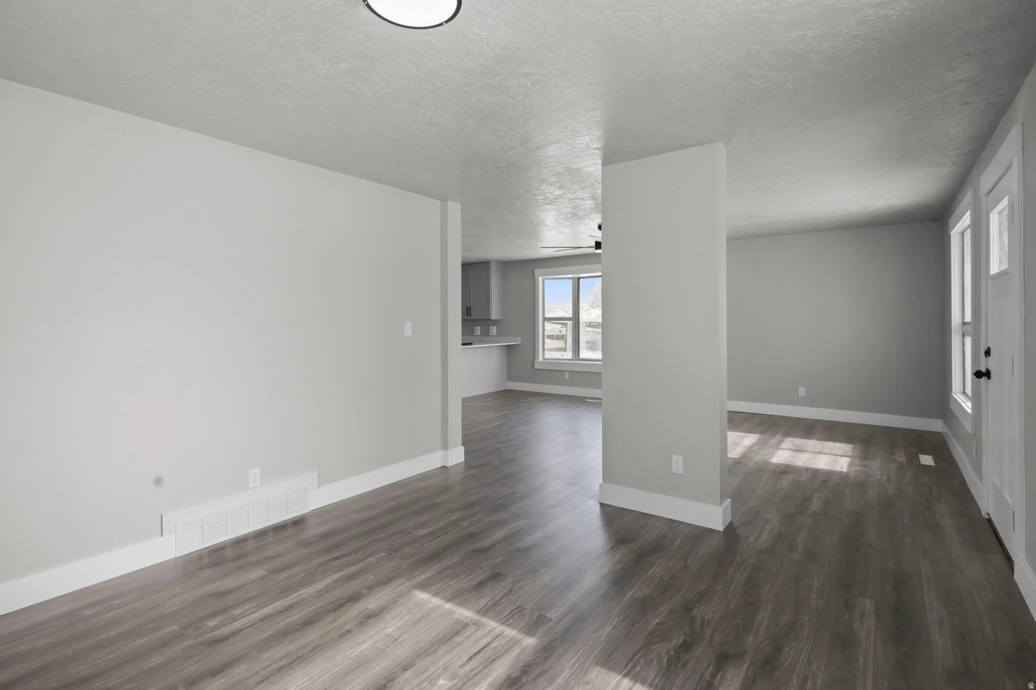 Spare room with a textured ceiling and dark wood-style flooring