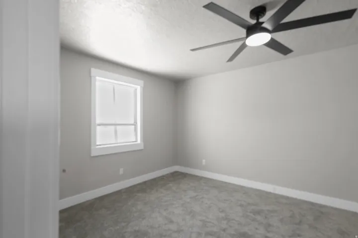 Empty room with carpet flooring, a textured ceiling, and ceiling fan
