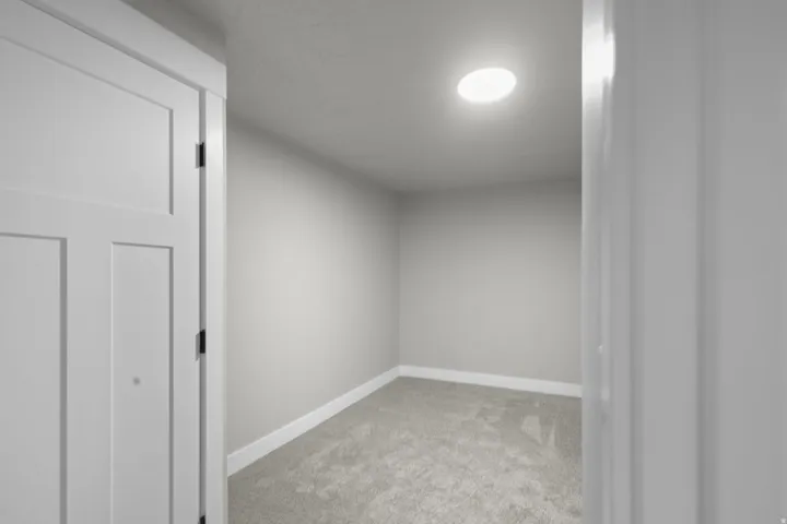Unfurnished room featuring light carpet and baseboards