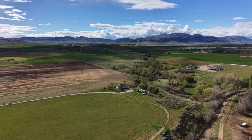 Expansive agricultural lands featuring varied terrain, including cultivated fields and pastures