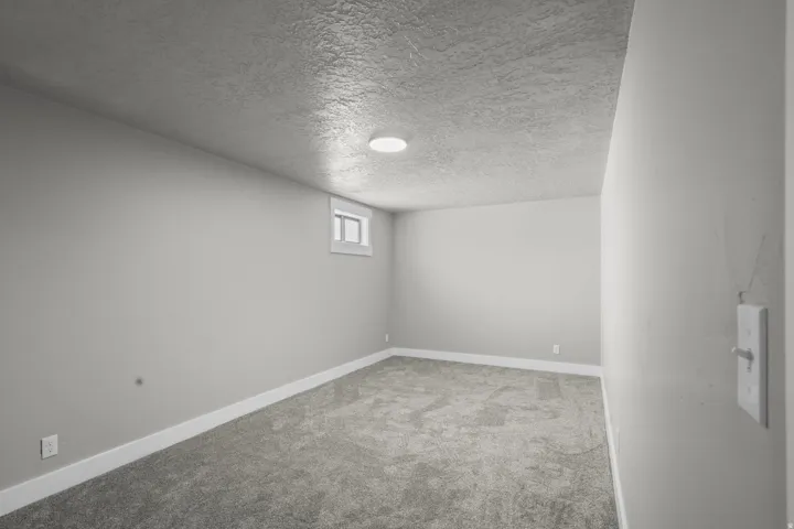 Basement with a textured ceiling and light carpet