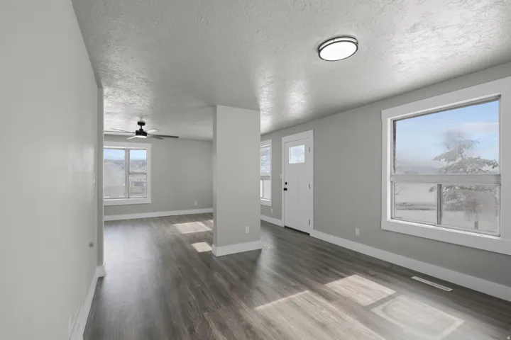 Foyer featuring dark wood-style flooring, a textured ceiling, and ceiling fan