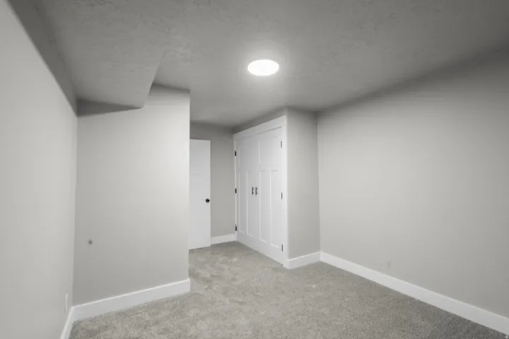 Bonus room with carpet and a textured ceiling