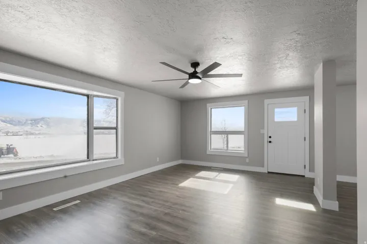 Foyer entrance with a ceiling fan, a textured ceiling, and dark wood-type flooring
