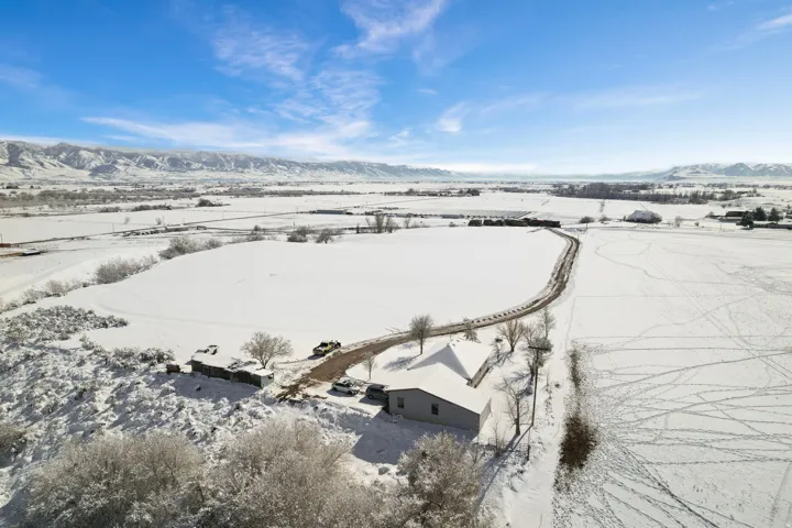 Snowy aerial view with a mountain view and a rural view