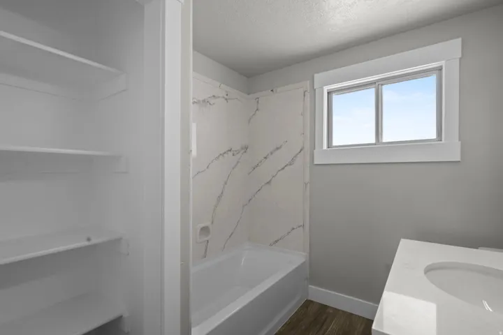 Full bath featuring vanity, a textured ceiling, dark wood-type flooring, and shower / washtub combination