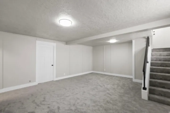 Finished basement with a textured ceiling and carpet floors