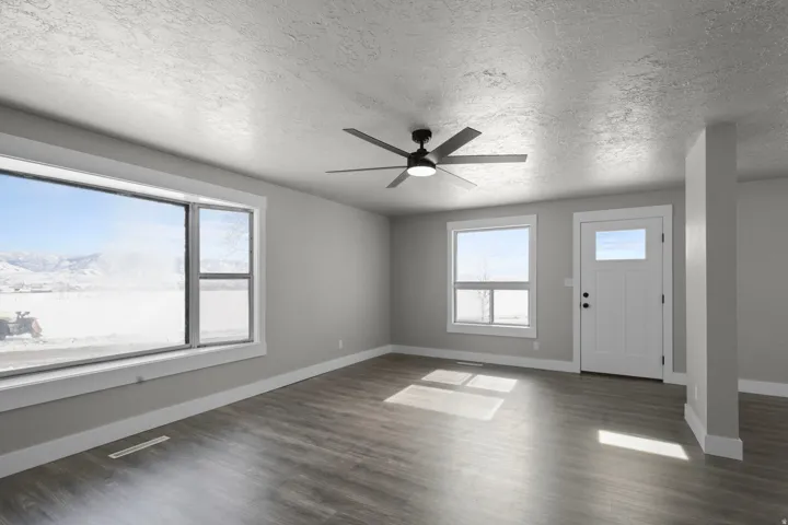 Entrance foyer featuring ceiling fan, a textured ceiling, and dark wood-type flooring
