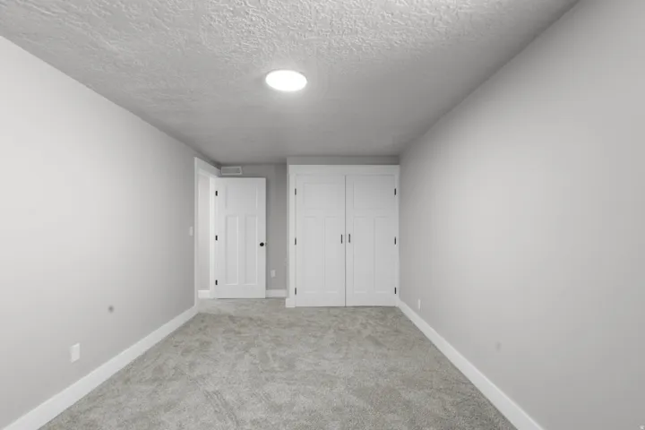 Unfurnished bedroom with carpet flooring, a closet, and a textured ceiling