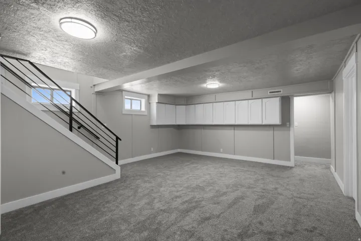 Basement featuring carpet and a textured ceiling