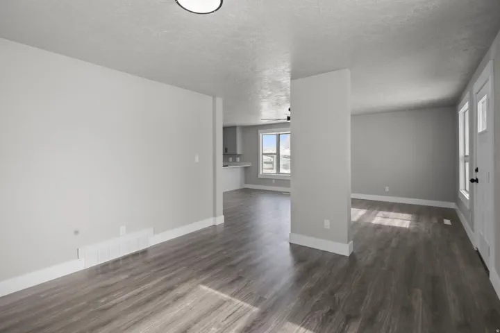 Spare room with a textured ceiling and dark wood-style flooring