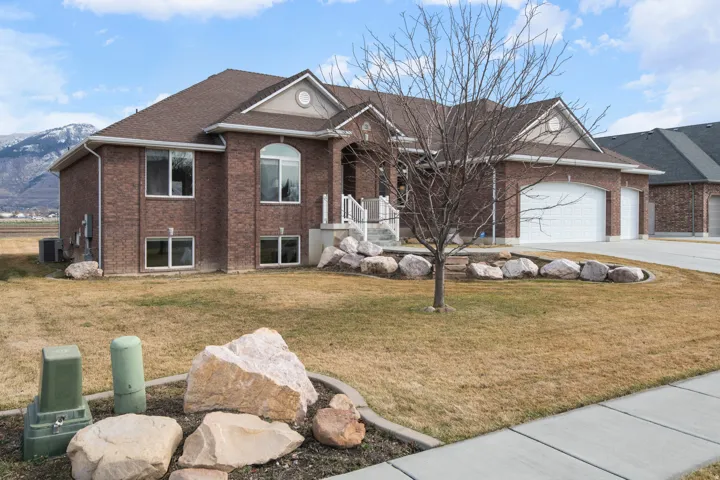 Ranch-style home with brick siding, a front yard, an attached garage, and driveway