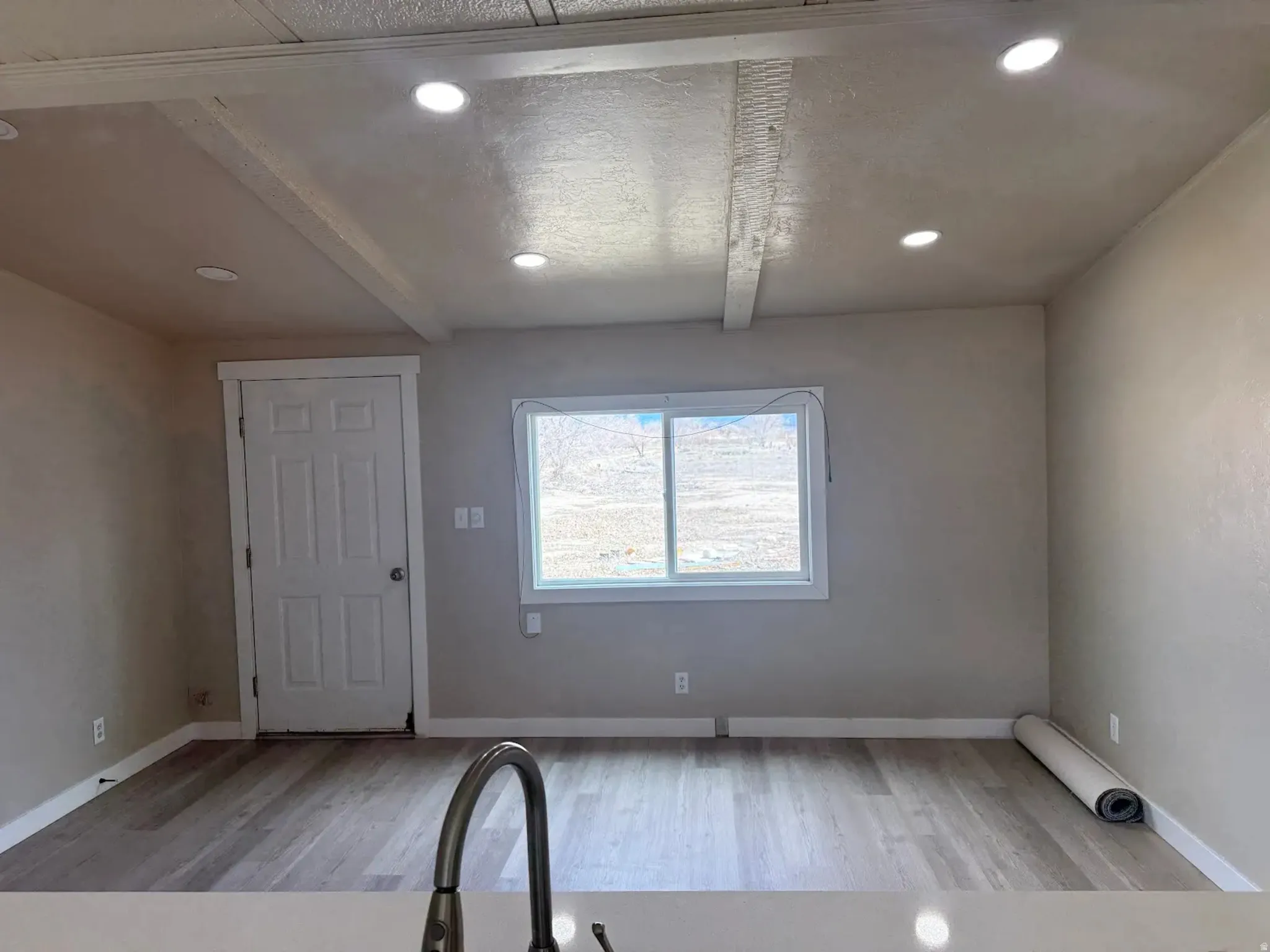 Entryway featuring light wood-type flooring, beamed ceiling, and recessed lighting