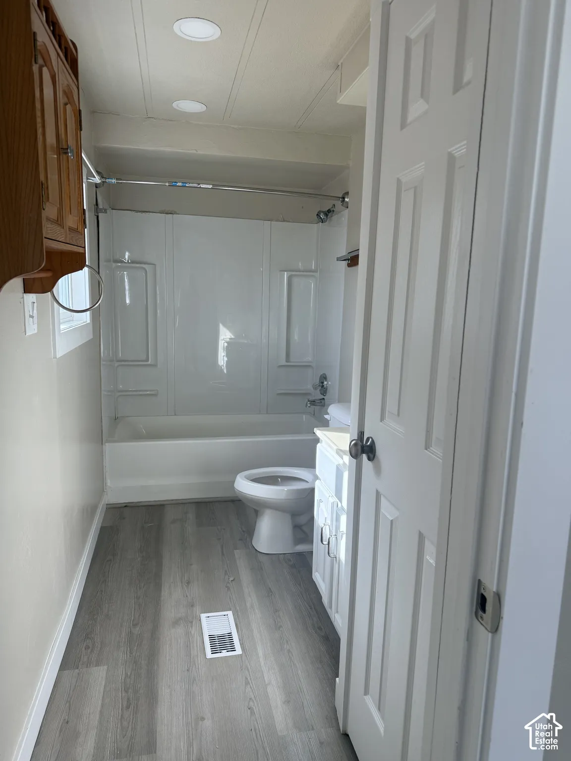 Full bathroom featuring vanity, shower / bath combination, and light wood-style floors