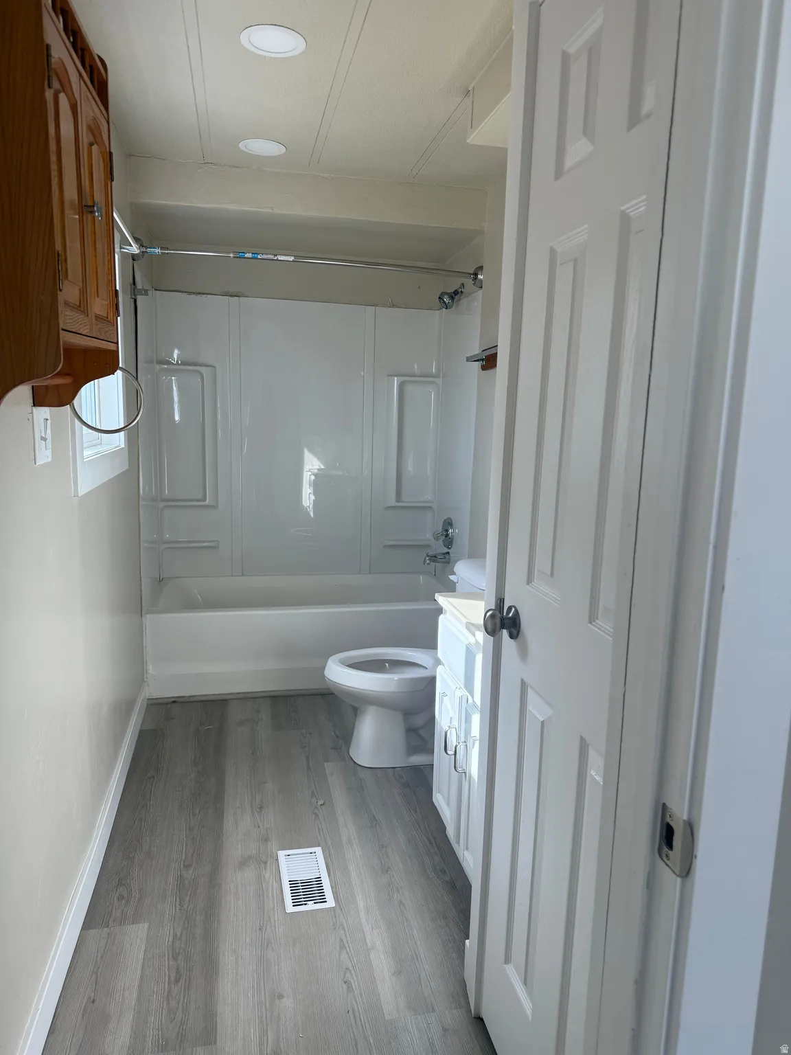 Full bathroom featuring vanity, shower / bath combination, and light wood-style floors