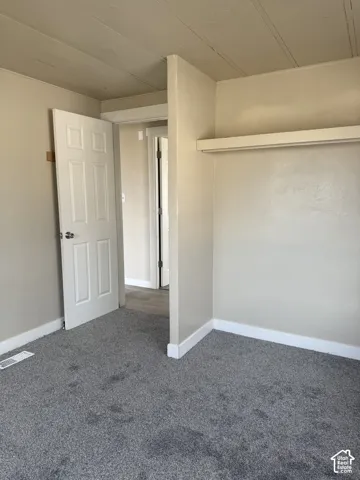 Unfurnished bedroom featuring carpet floors and baseboards