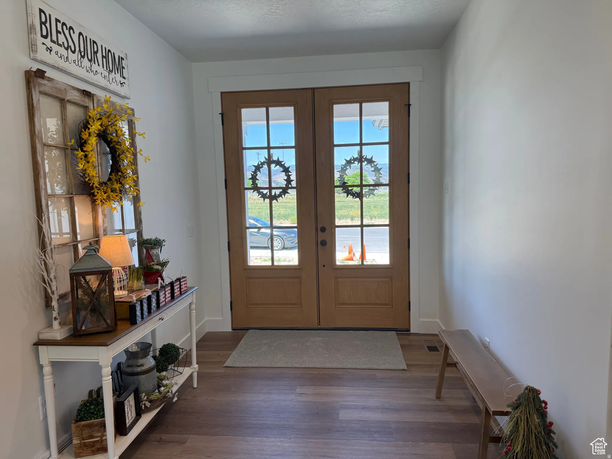 Doorway featuring french doors, wood finished floors, a water view, and a textured ceiling