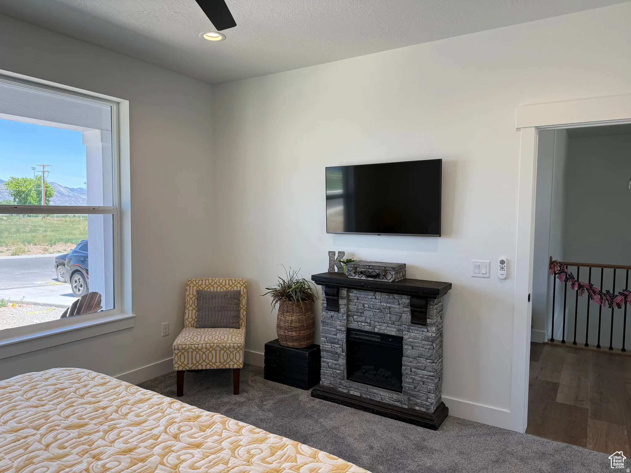 Bedroom with carpet floors, a stone fireplace, ceiling fan, and recessed lighting