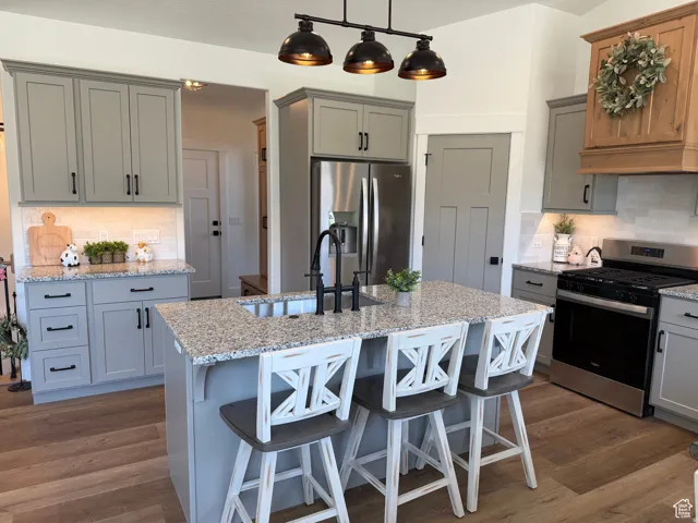 Kitchen with tasteful backsplash, gray cabinetry, and stainless steel appliances