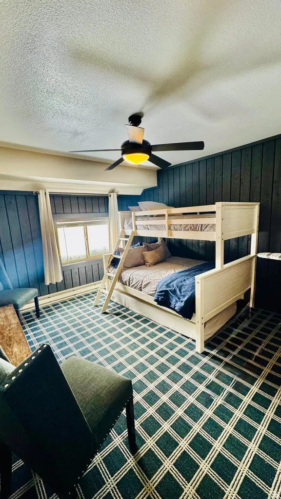 Bedroom with a textured ceiling, ceiling fan, and carpet