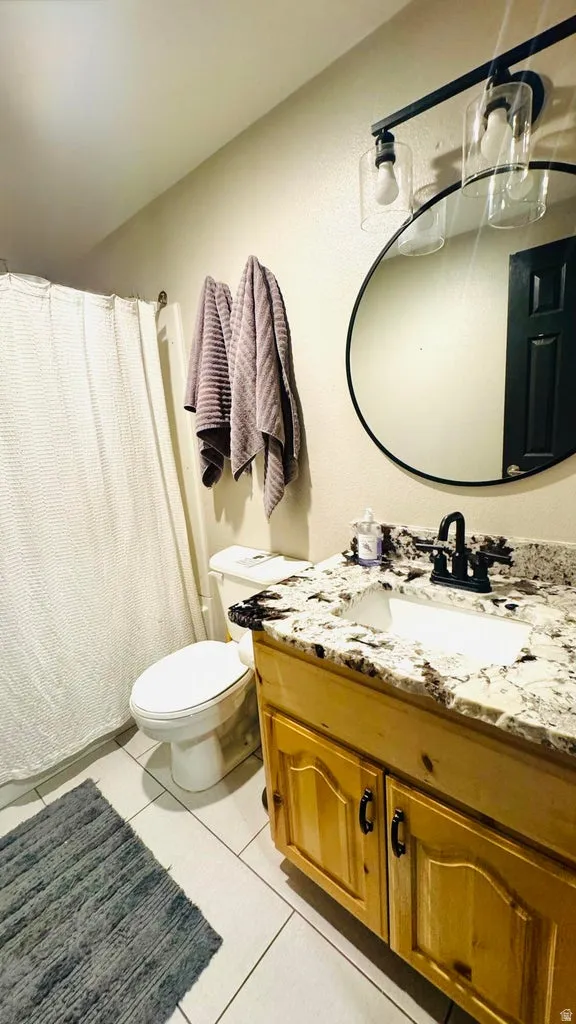 Bathroom with vanity, curtained shower, and light tile patterned floors