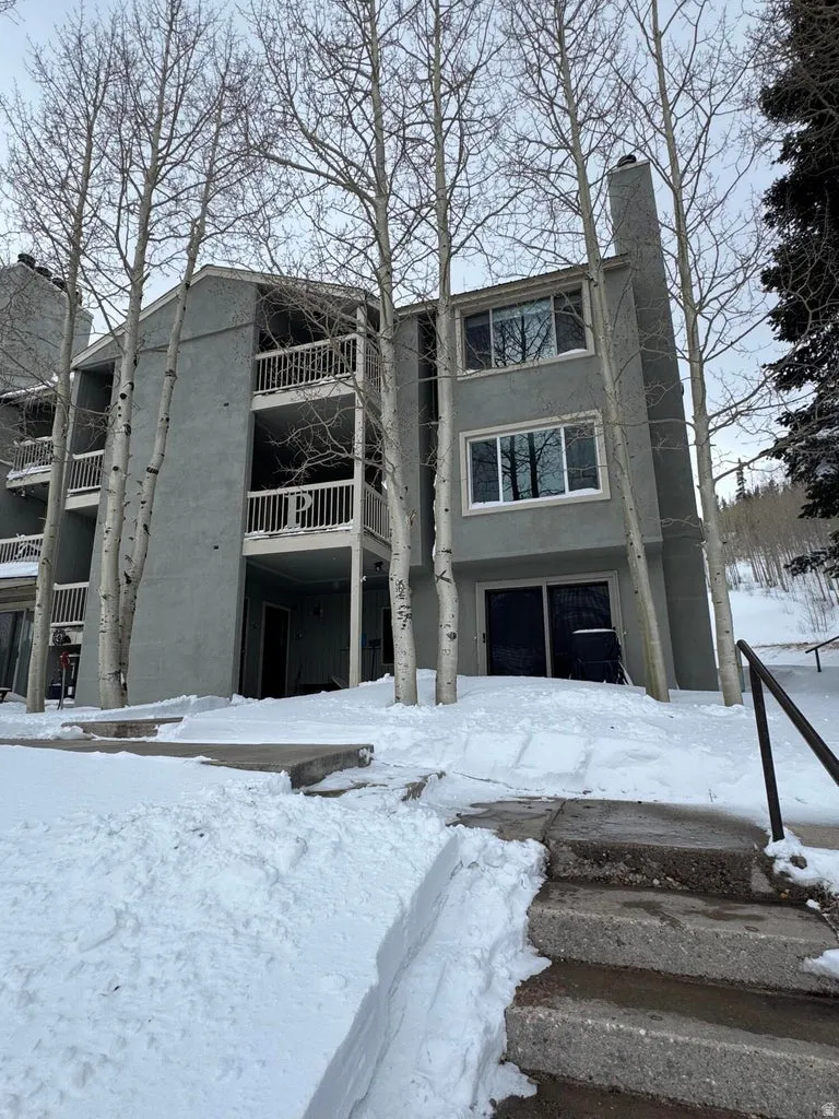 Snow covered building featuring a view of apartment building / complex