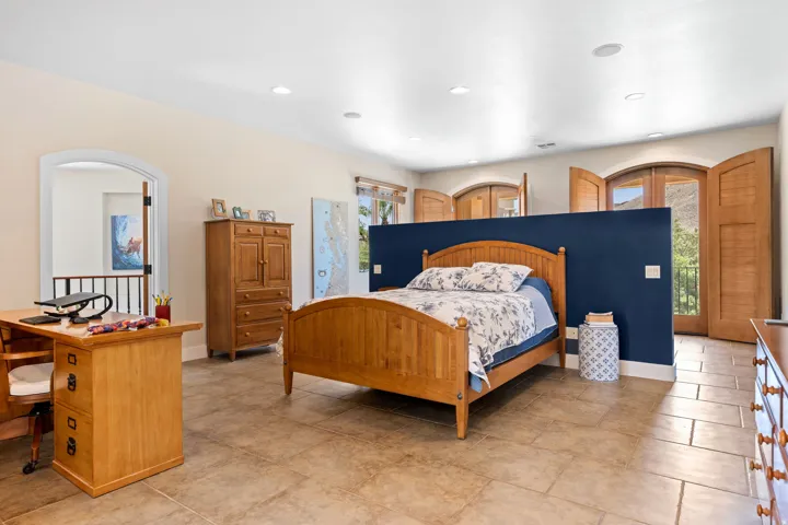 Bedroom with access to outside, recessed lighting, and arched walkways