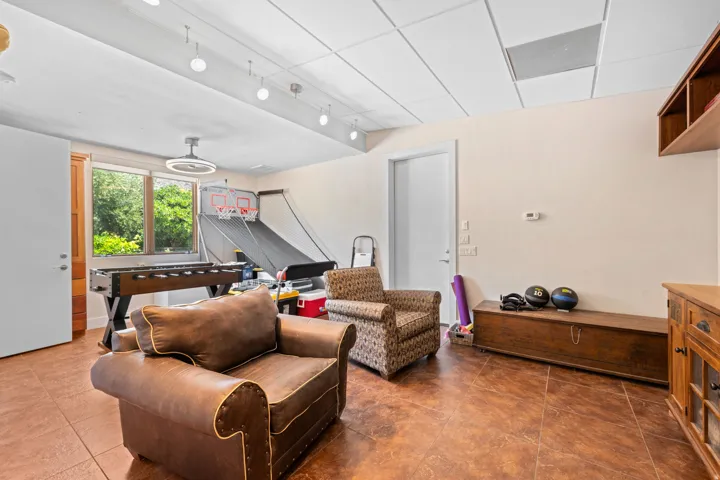 Living room with a drop ceiling, rail lighting, and dark tile patterned flooring