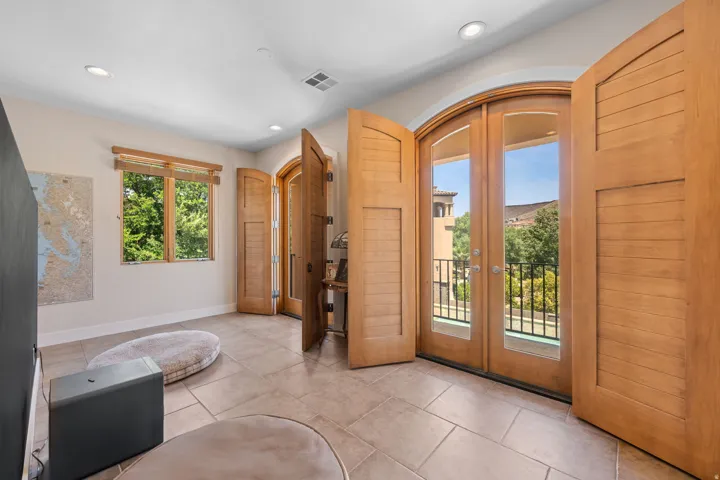 Foyer featuring arched walkways, french doors, recessed lighting, and tile patterned flooring