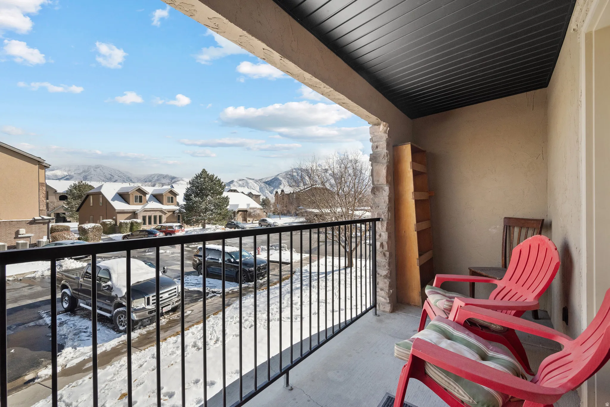 Snow covered back of property featuring a mountain view and a residential view