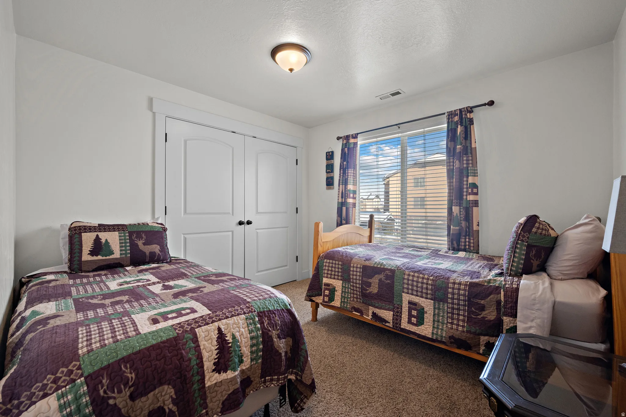 Bedroom with a closet, carpet, and a textured ceiling