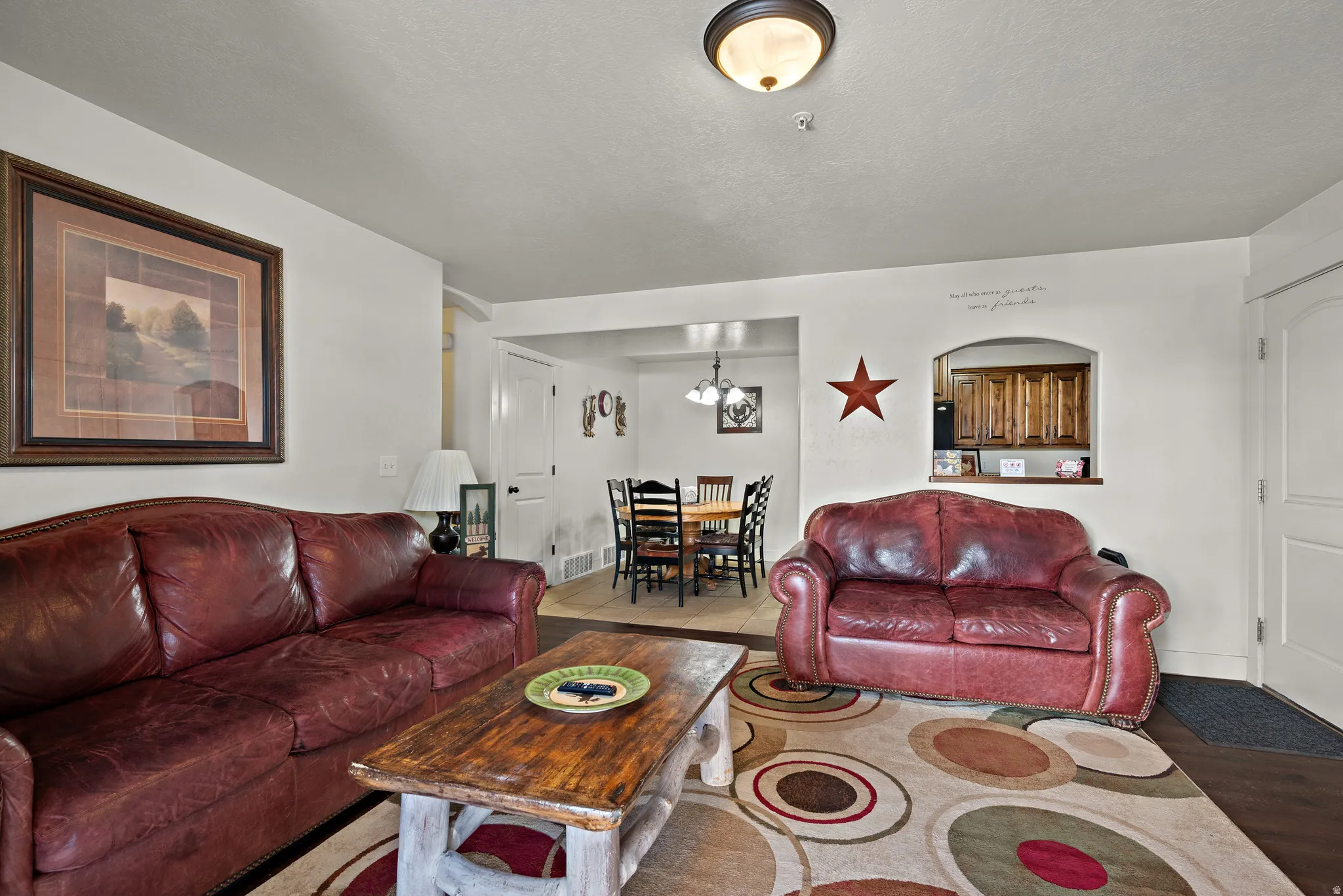 Living room with suspended lighting and a textured ceiling