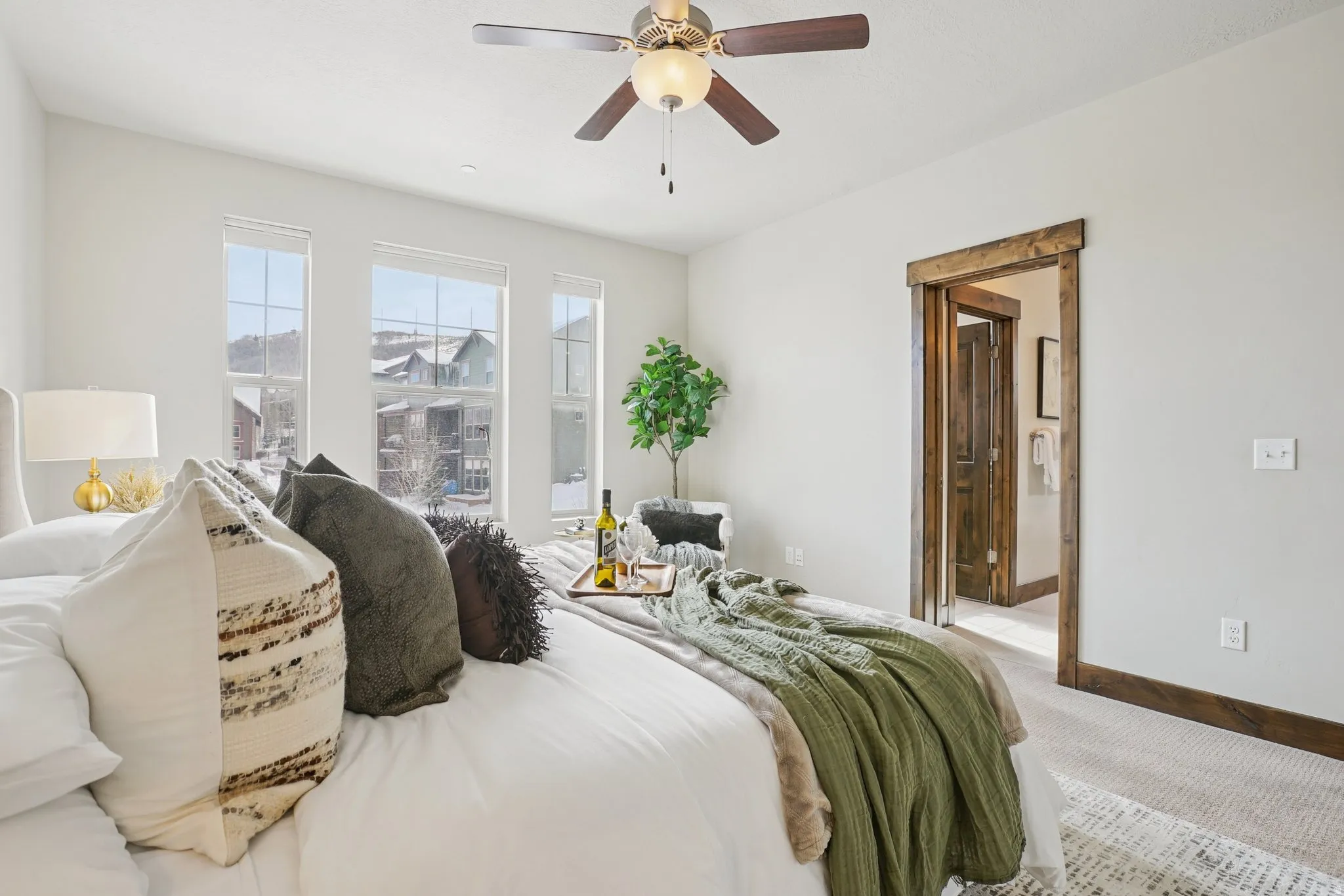Carpeted bedroom with a ceiling fan and ensuite bath