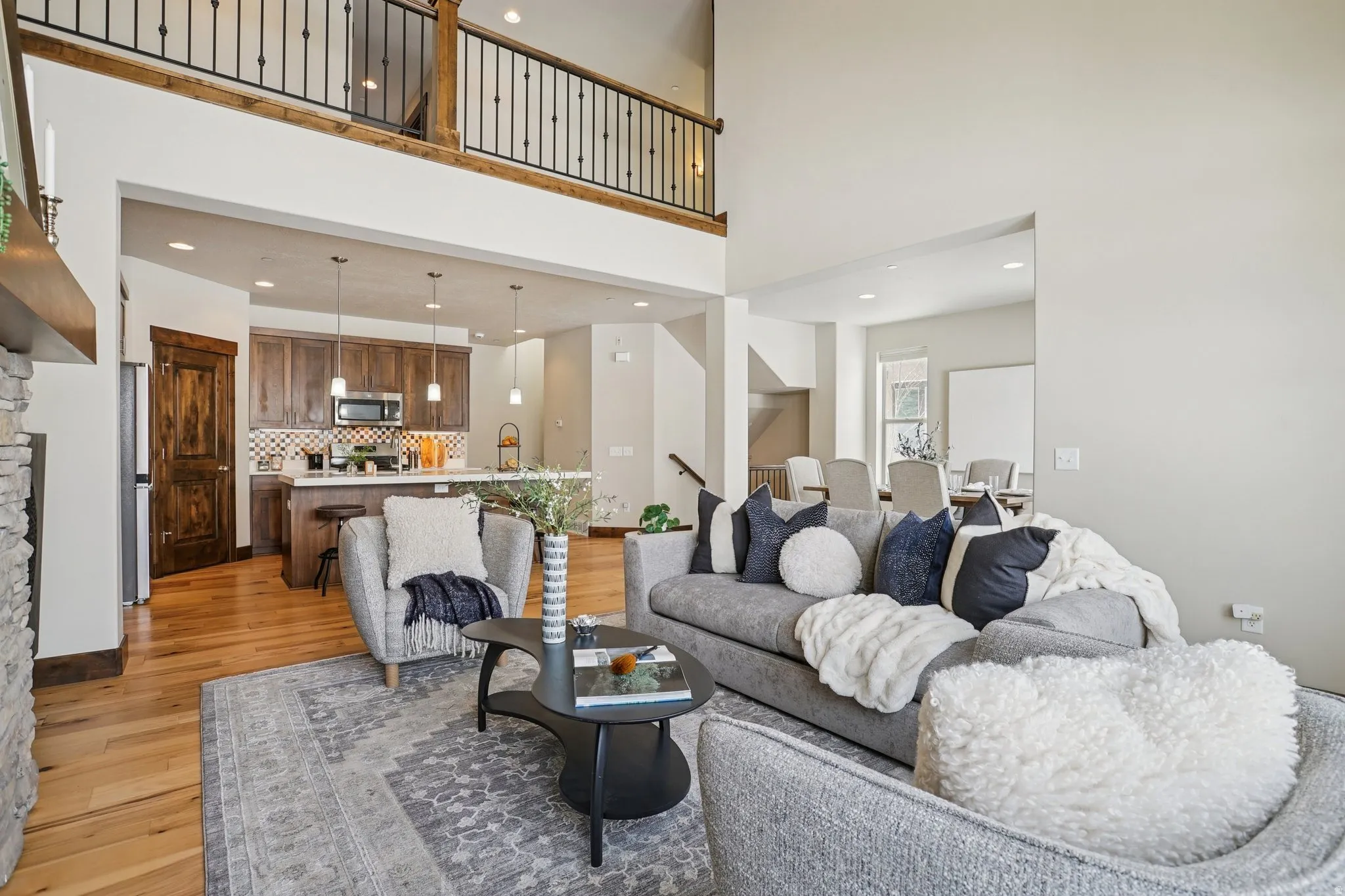Living room featuring light wood-style floors, recessed lighting, and a high ceiling