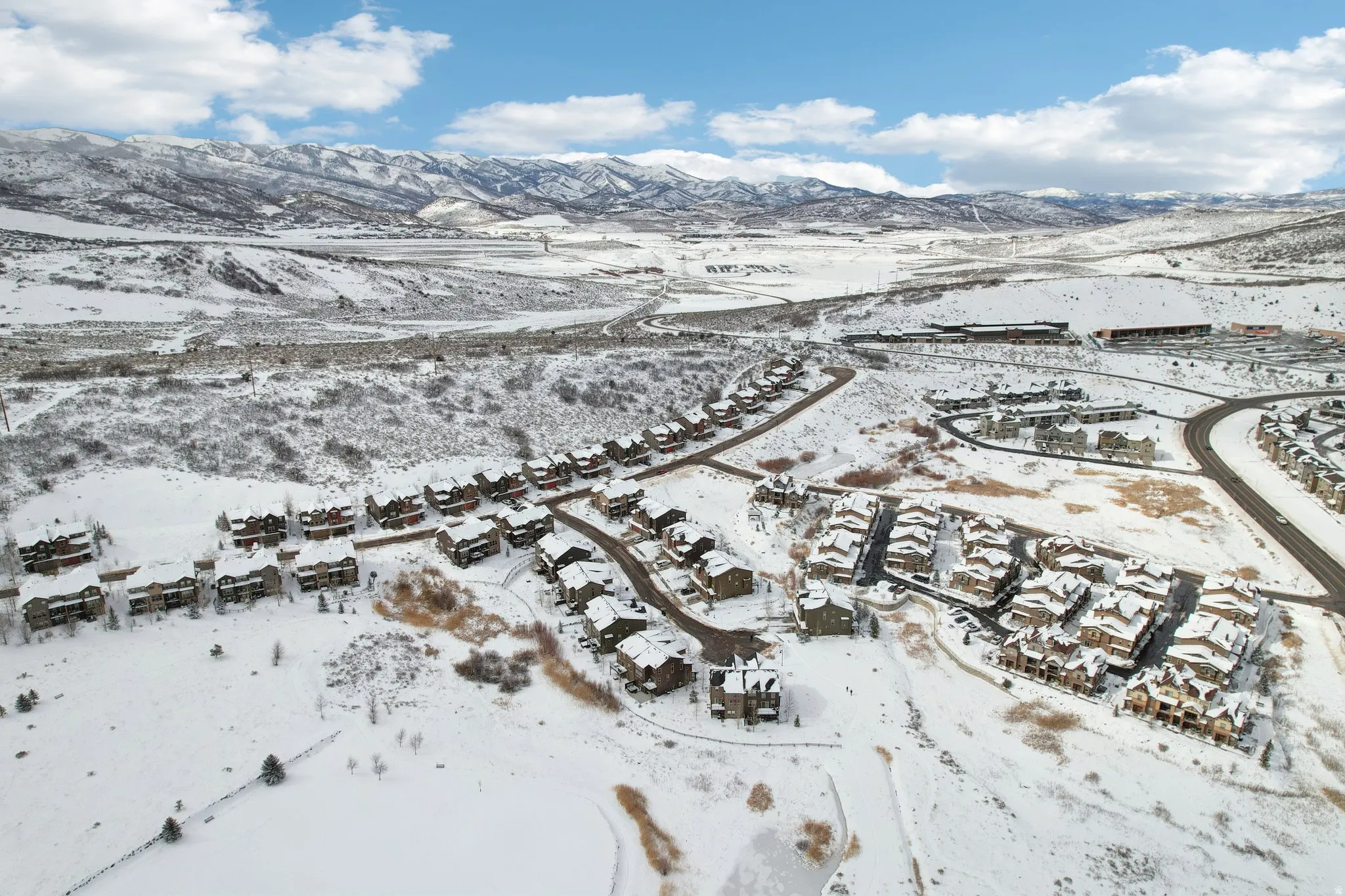 Snowy aerial view featuring a mountain view and a residential view